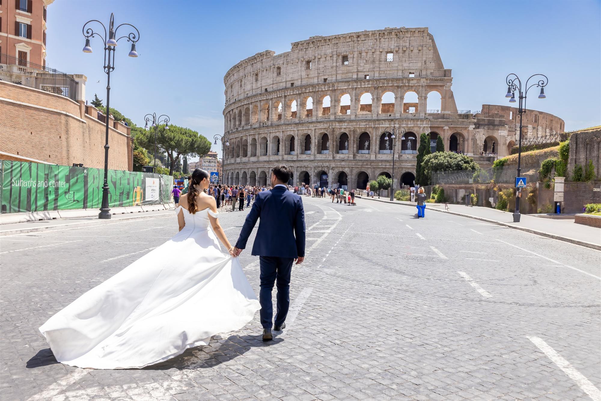 Sposi che camminano mano nella mano verso il Colosseo, a Roma